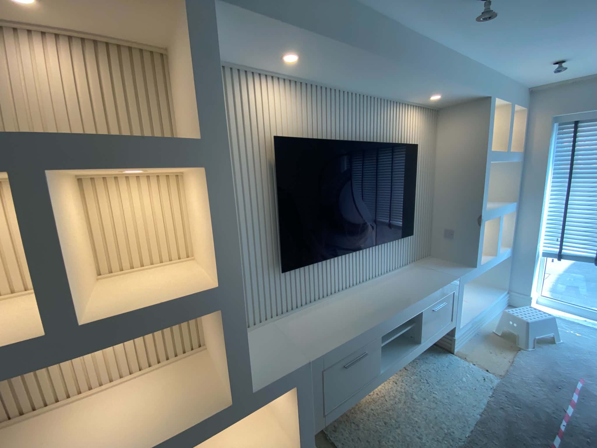 Media wall with floating shelves, LED lighting and display niches