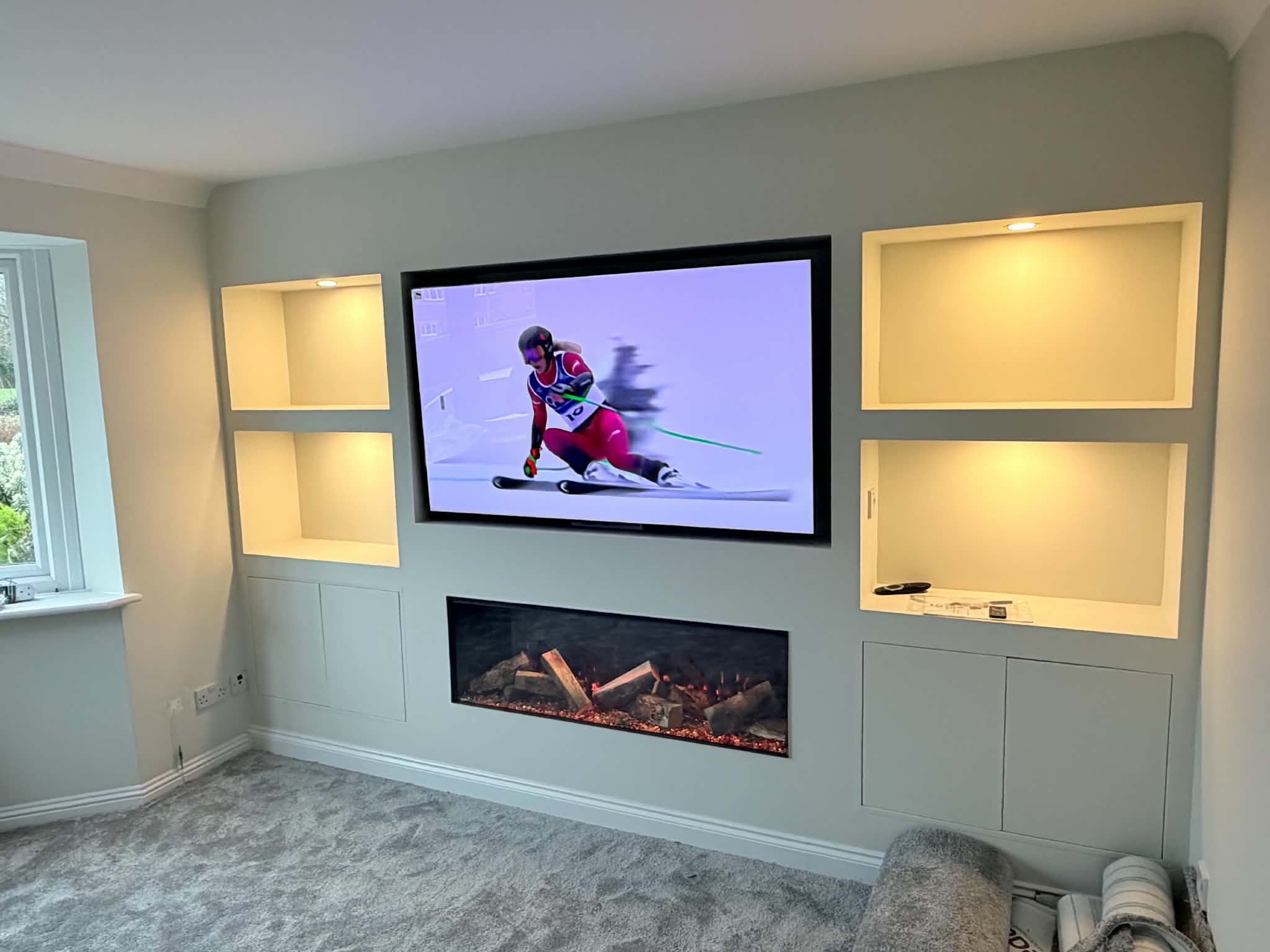 Grey media wall with electric fire and LED-lit display niches