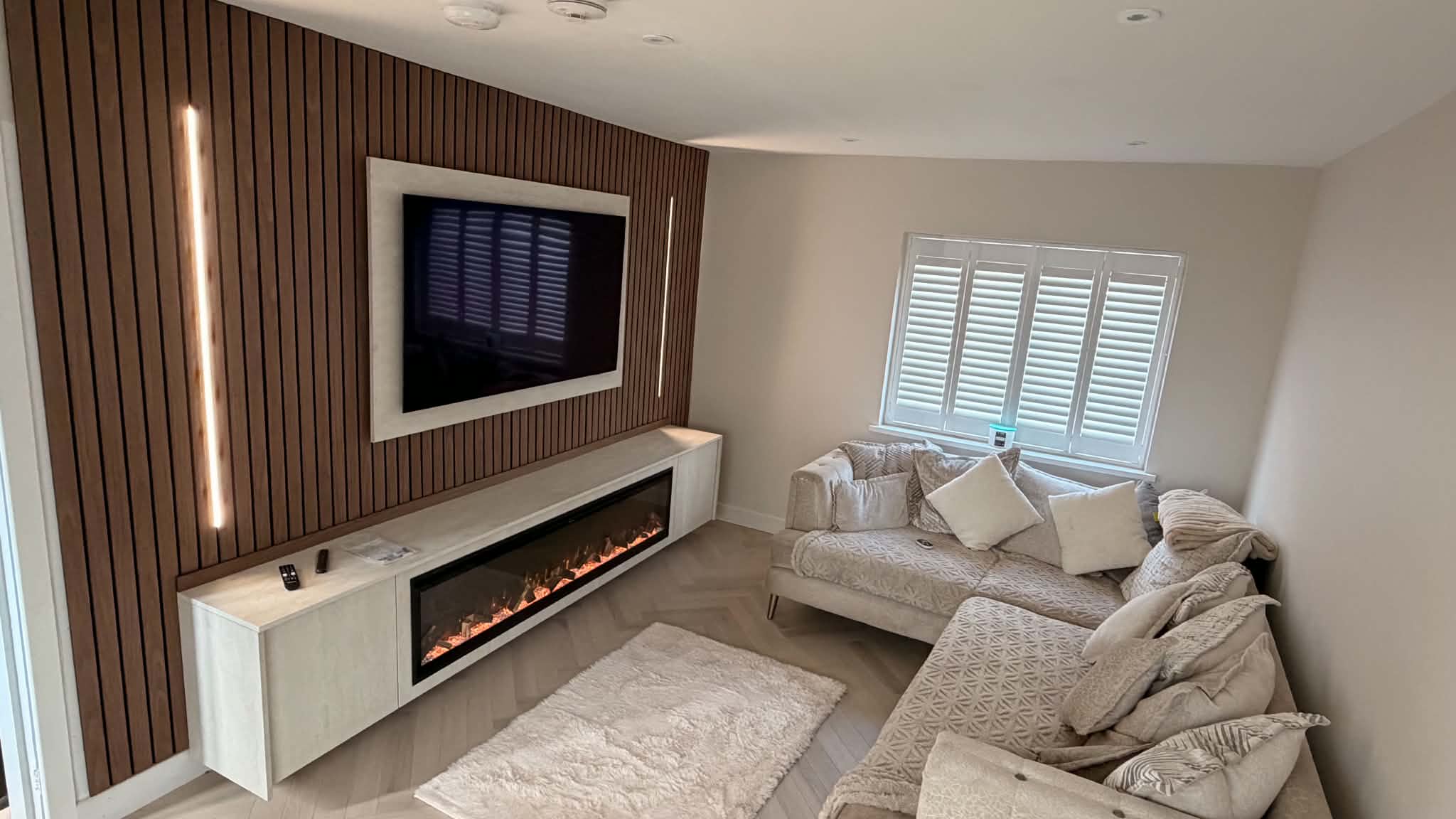 Oak slatted TV media wall with floating cabinet and no fireplace